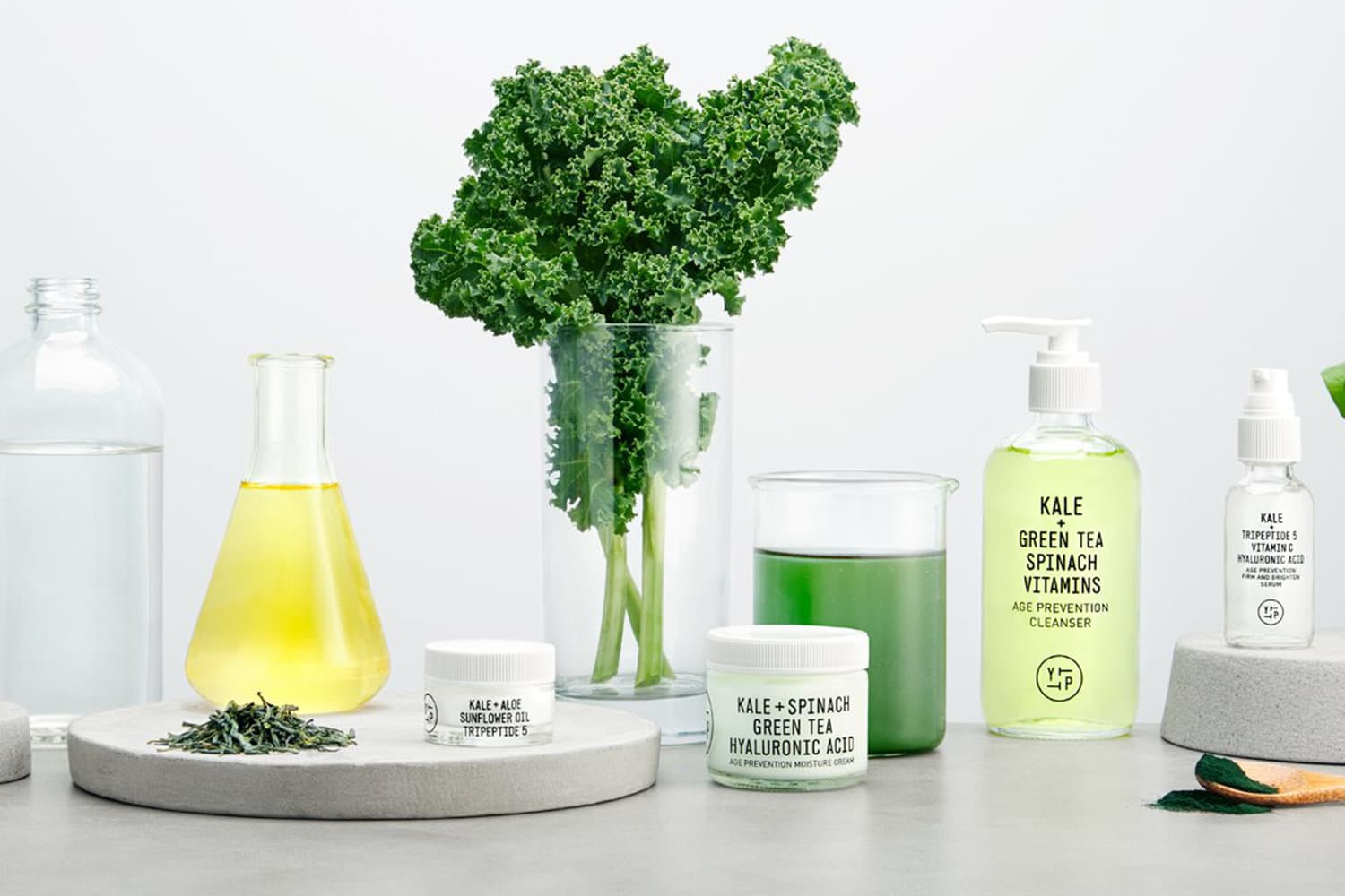 Youth to the People kale-based skincare products with fresh kale and laboratory glassware